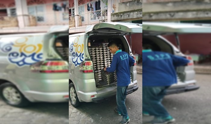 Tumpukan Kotak Makanan Siap Dibagikan, dengan Kepala Madrasah Afrinal Mengawasi Tumpukan Kotak Makanan Siap Dibagikan, dengan Kepala Madrasah Afrinal Mengawasi